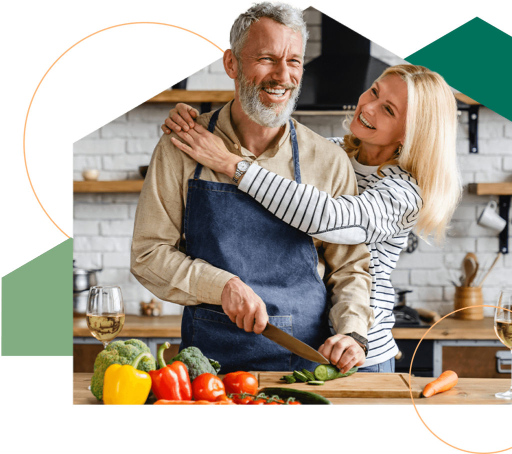 Happy retired couple preparing food in their home kitchen.